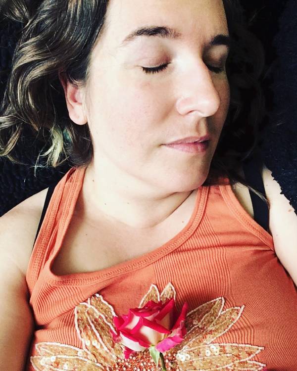 A head and shoulders photo of Angie Ebba, a woman with ankylosing spondylitis, fibromyalgia and migraine. She looks asleep and her eyes are sightly furrowed.